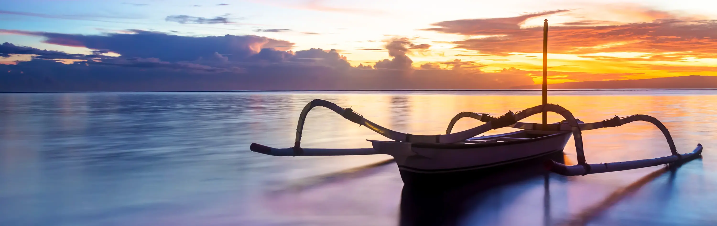A tranquil sea, with calm waters and outrigger floating, reflects the potential for beauty in life when one achieves optimal mental wellness