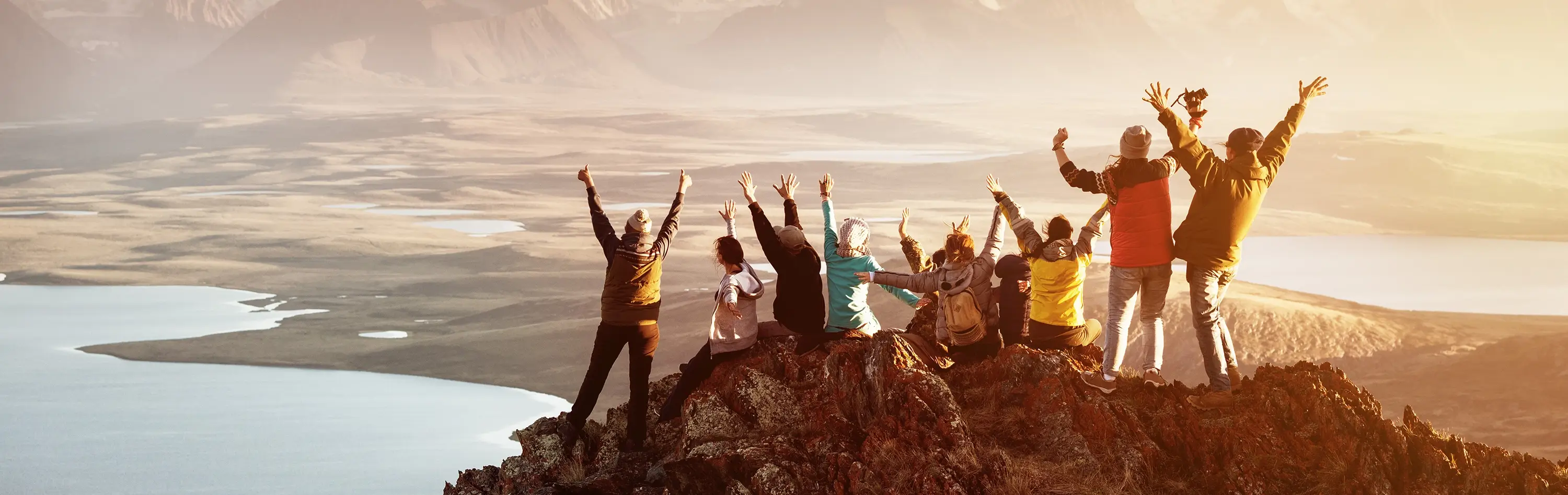 A group of individuals at the summit of a mountain, raising their arms in celebration, symbolizes how recovery from mental conditions is achievable for all.